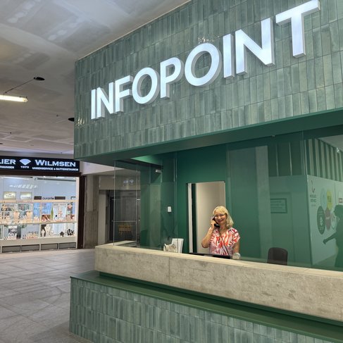 neuer Infopoint in grün mit Frau die telefoniert