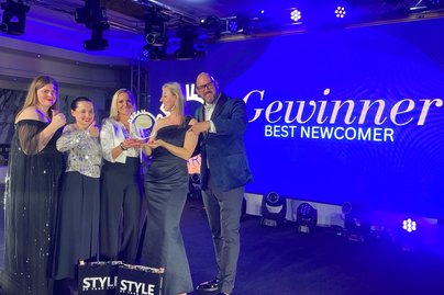 Zero gewinnt Retail Award: Gruppe von Menschen mit Trophäe in der Hand 