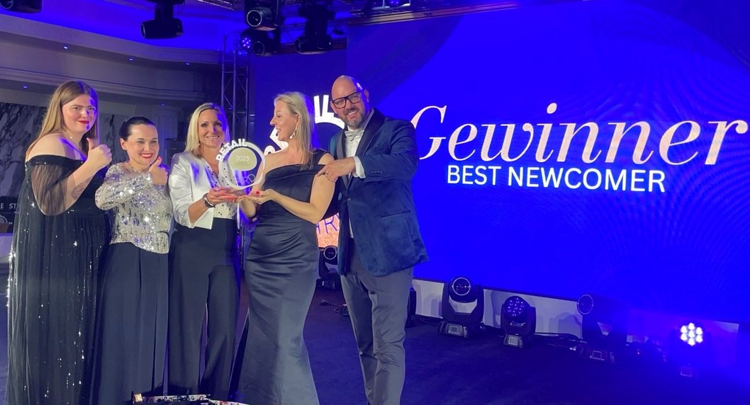 Zero gewinnt Retail Award: Gruppe von Menschen mit Trophäe in der Hand