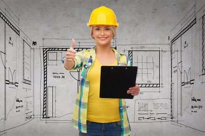 Bauarbeiterin mit Helm und Plan in der Hand 