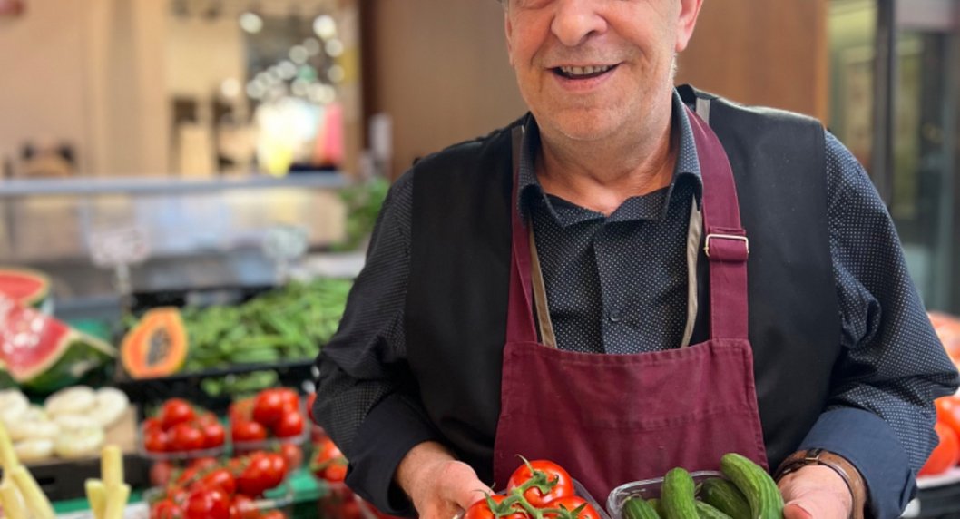 Mann mit Tomaten und Gurken in der Hand